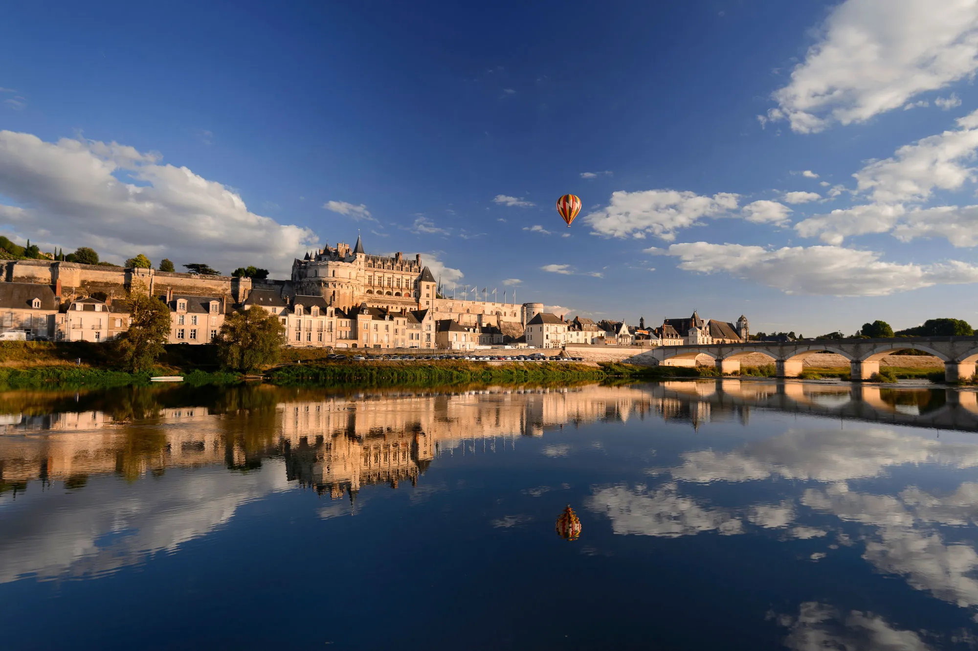 Vue sur le château d'Amboise et la Loire, une montgolfière dans le ciel
